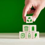This Is A Photo Of A Person Stacking Wooden Blocks With Various Sustainability-related Images Printed On Them.