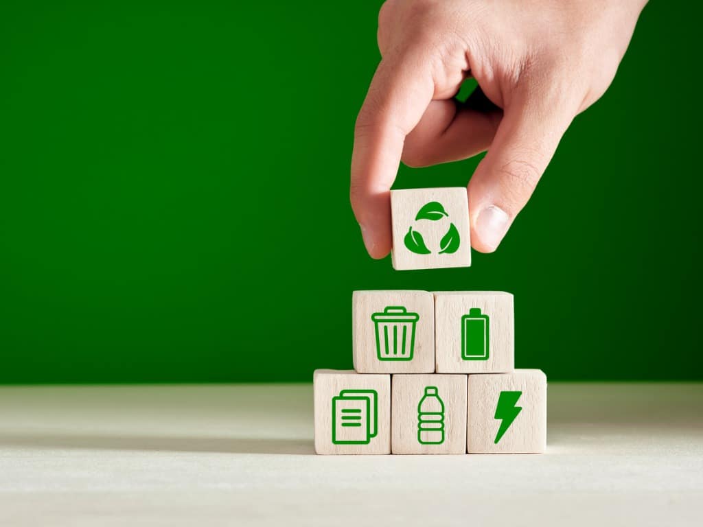 This is a photo of a person stacking wooden blocks with various sustainability-related images printed on them.