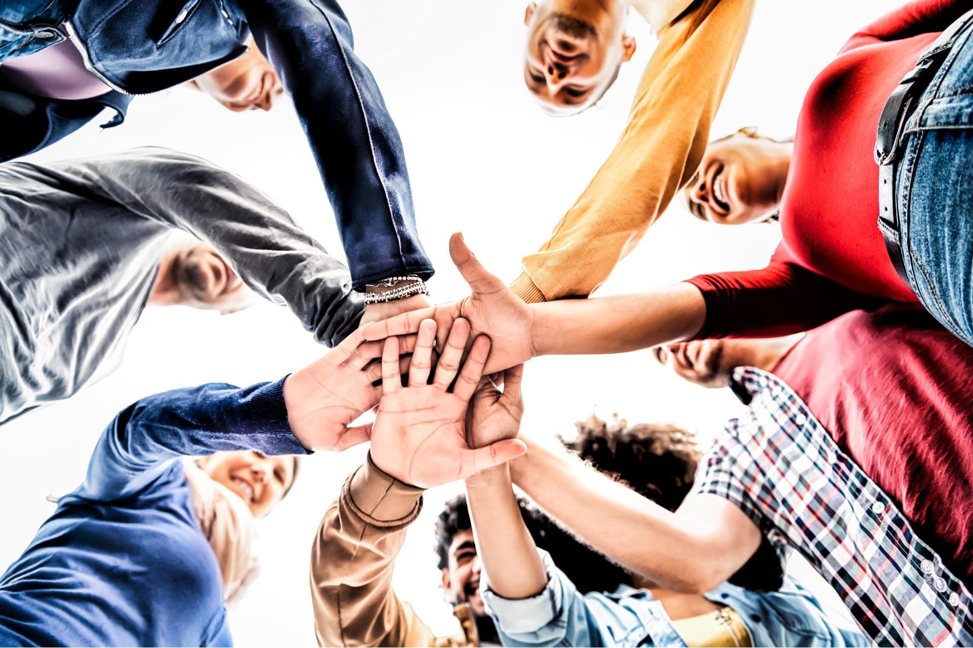 This is a photo of a group of coworkers putting their hands together.